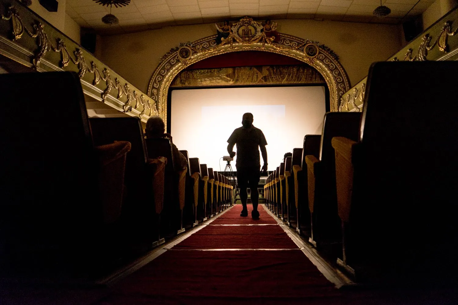 Una persona camina hacia el escenario de un teatro para hablar en público