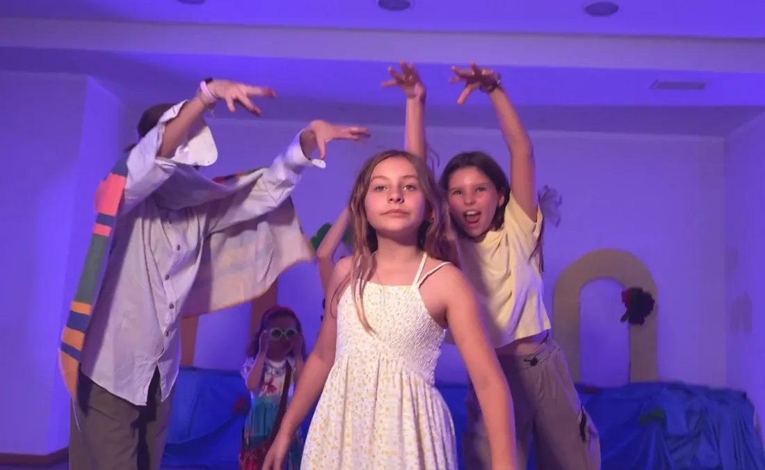 Alumnas de la escuela de Escena Zero en escena, bajo luz de escenario, en una muestra